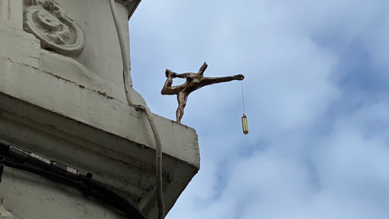 Foto van ZieMie beeldje Vrouwe Justitia van Mie Bogaerts tegen een blauwe wolkenhemel.