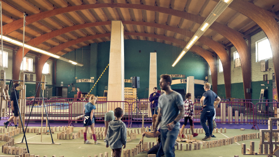 Mensen lopen rond in zaal waar dominoblokjes zijn opgesteld