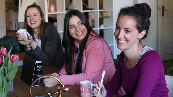 Drie vrouwen aan een tafel in meeting