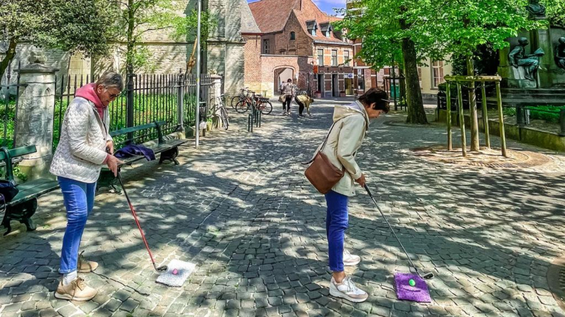 Twee golfende vrouwen in stad Kortrijk