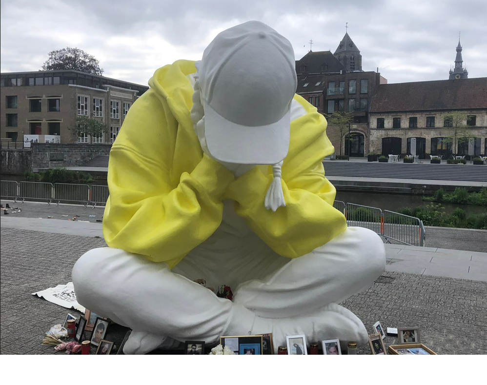 groot wit kunstwerk van een tiener in kleermakerszit, met felgele hoodie