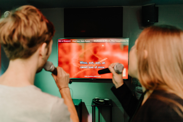 Twee mensen staan voor een scherm voor karaoke